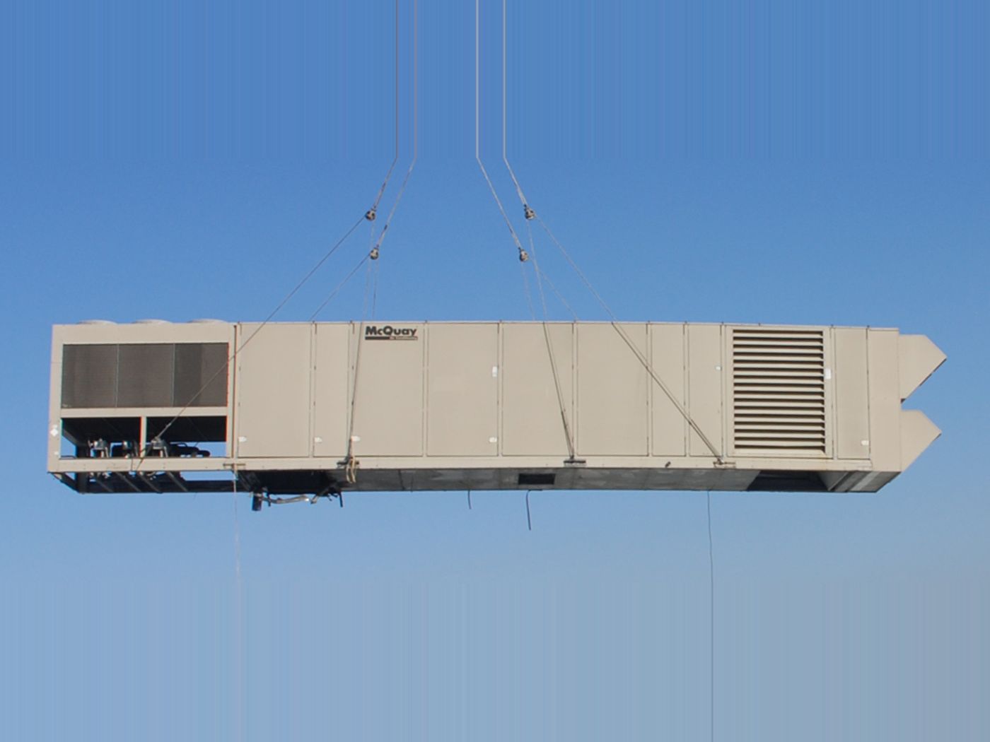 Packaged rooftop HVAC unit being lifted into place by crane