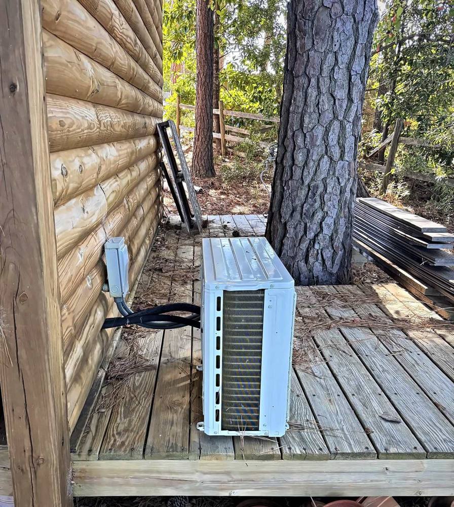 Mini split outdoor unit with insulated line set and disconnect on a log cabin